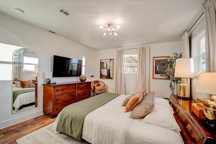 The thoughtfully curated primary bedroom is inviting, swoon worthy, and perfect for comfortably watching movies on the 55" TV or sleeping in with room darkening curtains.