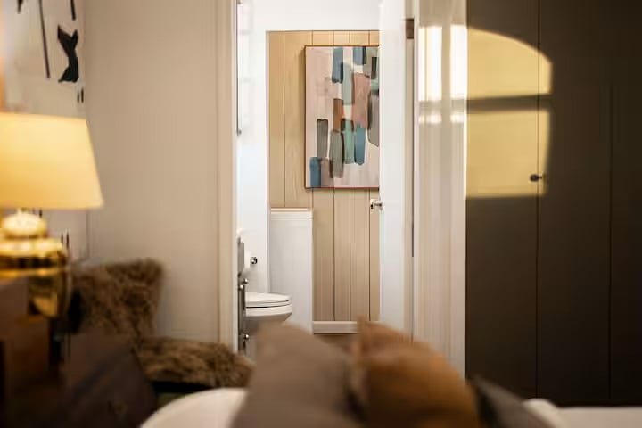 View of the primary bedroom into the en suite bathroom and laundry area with full size washer and dryer.