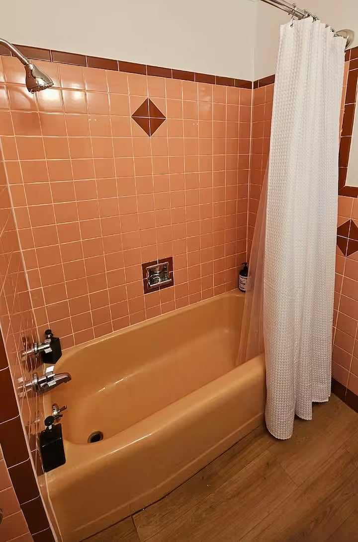 The guest bath has a tub/shower combo with original 1960s pink bathtub and tile! The shower head is new with adjustable water spray.
