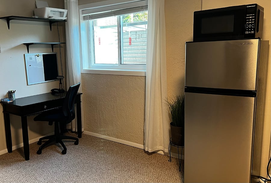 Large capacity compact refrigerator & dedicated workspace for remote work or business travel.