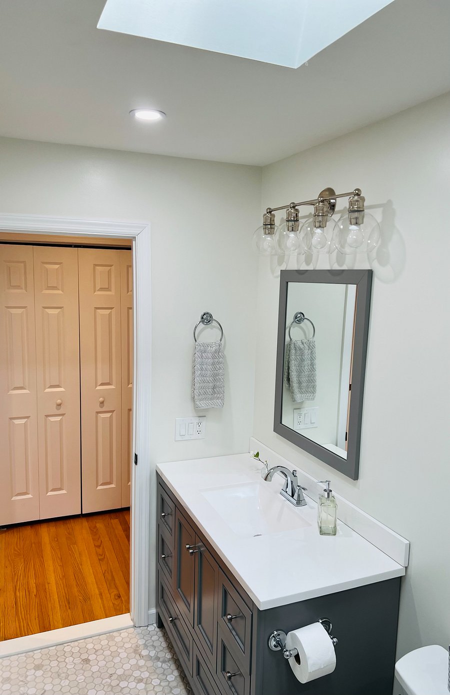 Bathroom vanity and hallway double door storage closet