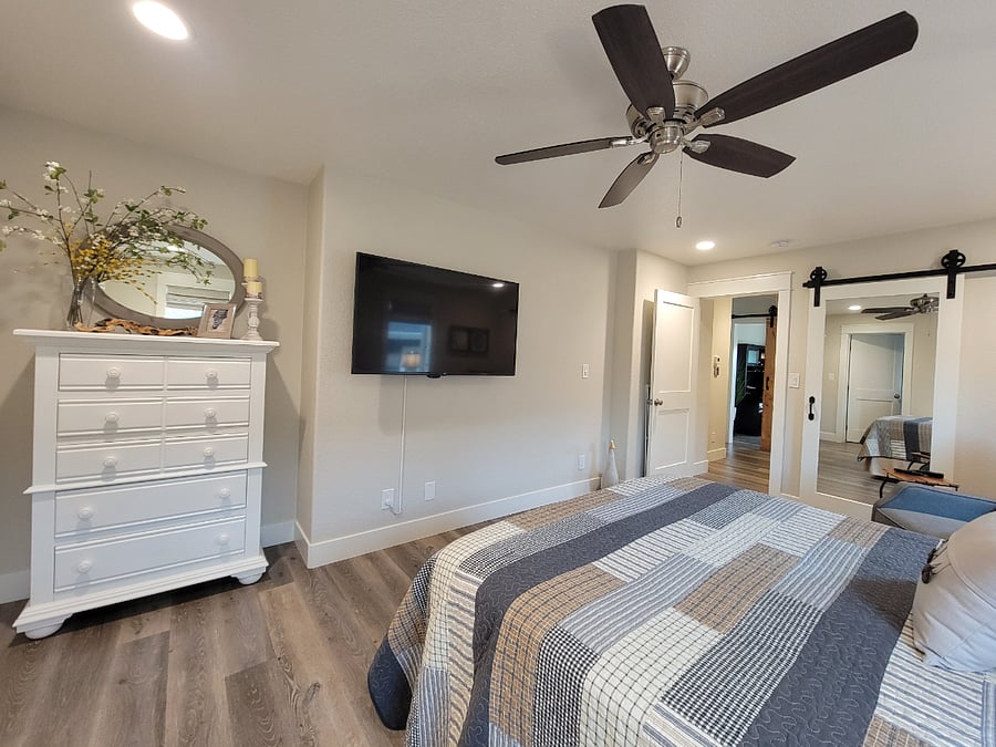 Primary bedroom with dresser and 52 smart tv