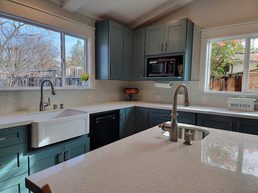 Fully equipped kitchen with multifunction microwave, dishwasher and large bright white quartz countertop.