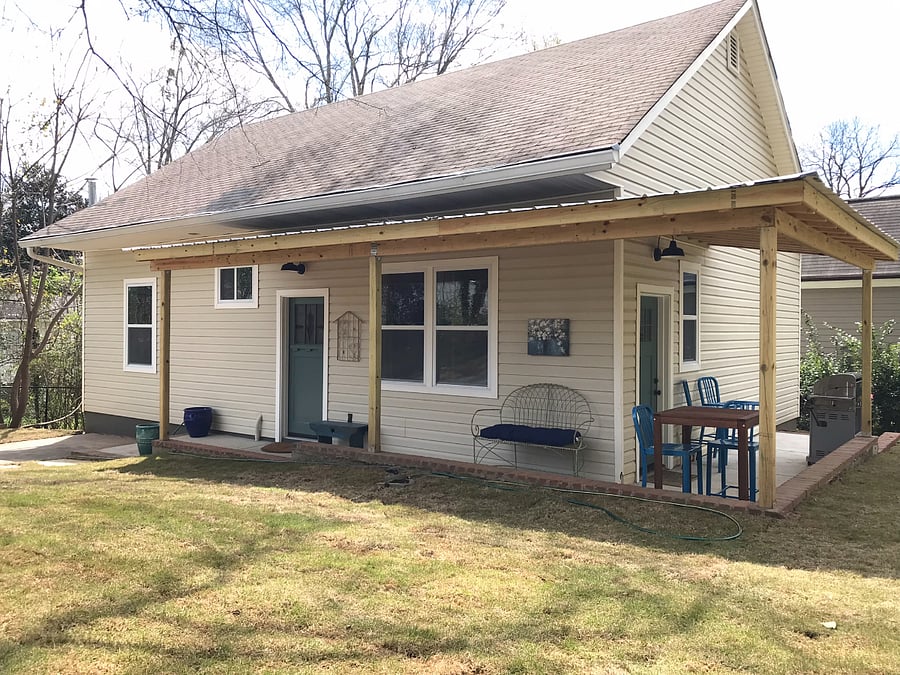 House exterior with covered porch, furniture and gas grill