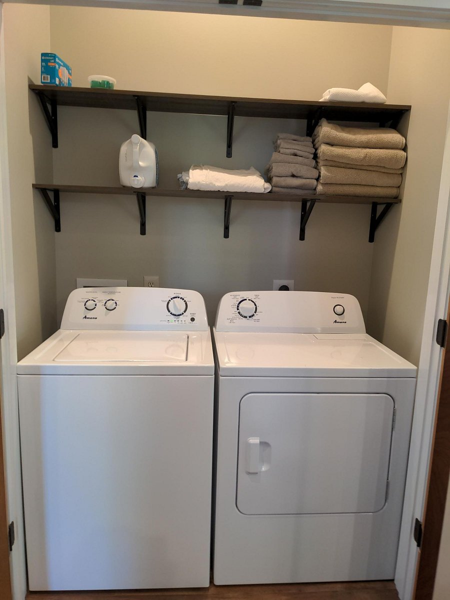 Laundry room with full size washer and dryer and shelves