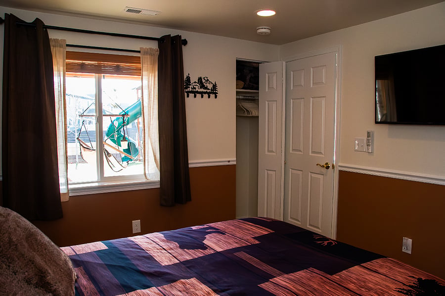 Bedroom looking towards the closet, door, and window. The Smart TV is ready for you to login and access your streaming services.