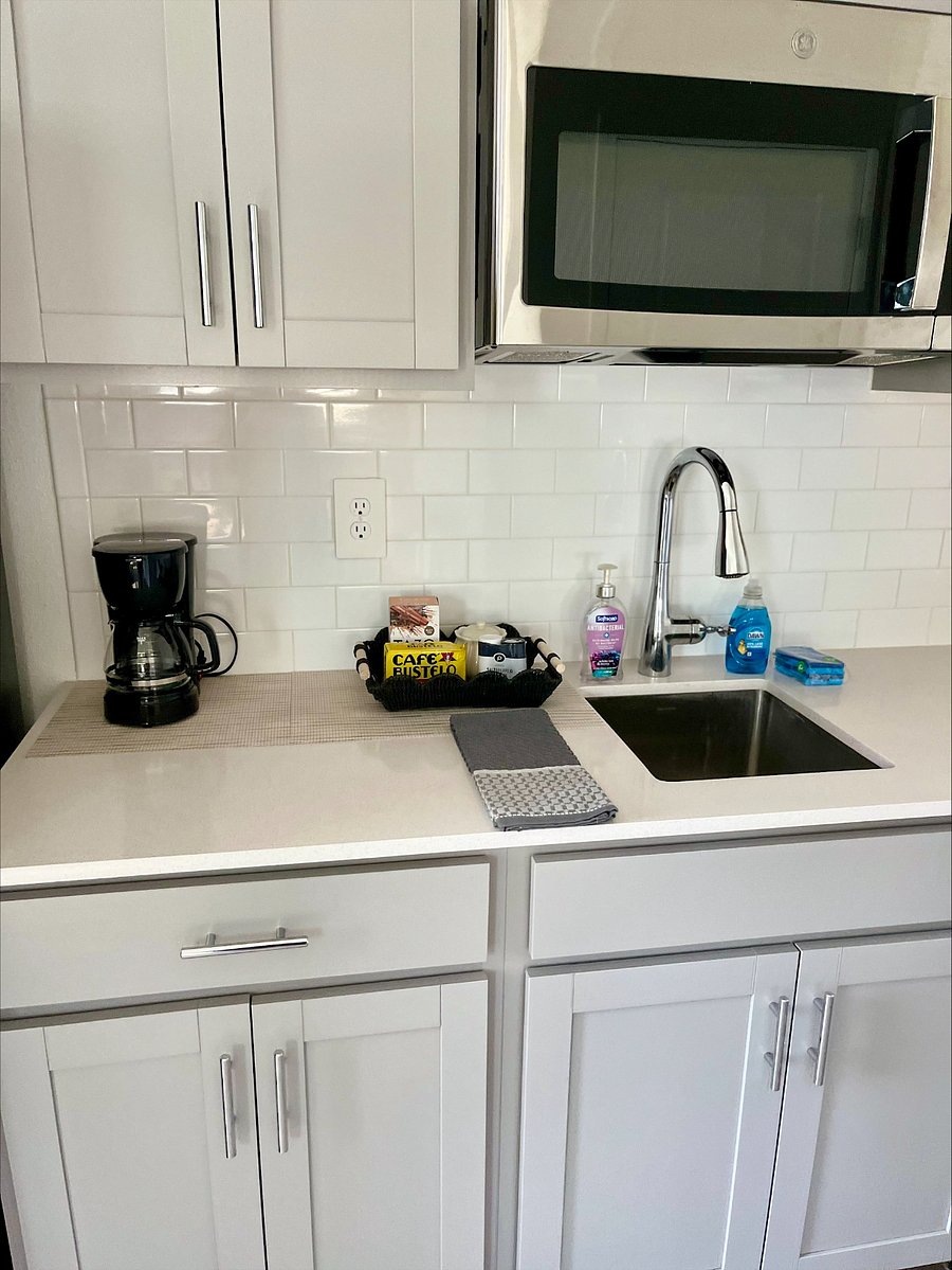 Fully equipped kitchen with plates, silverware, and cookware. Please note: The kitchen does not have a traditional stove, but is equipped with two convenient hotplates for cooking. Also includes coffee maker, dishwasher, full-size refrigerator, and microwave