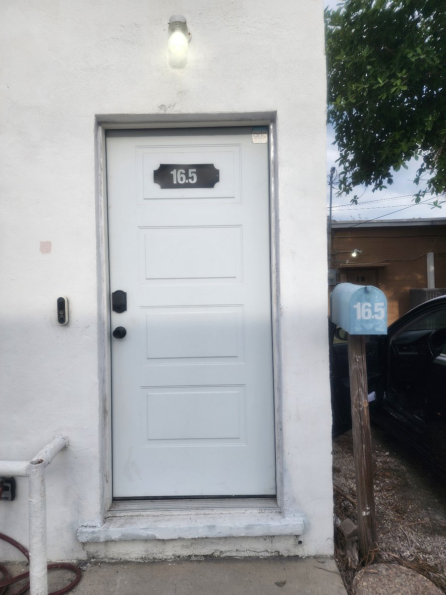 Front door at he rear of the building by loading zone with Blue mailbox