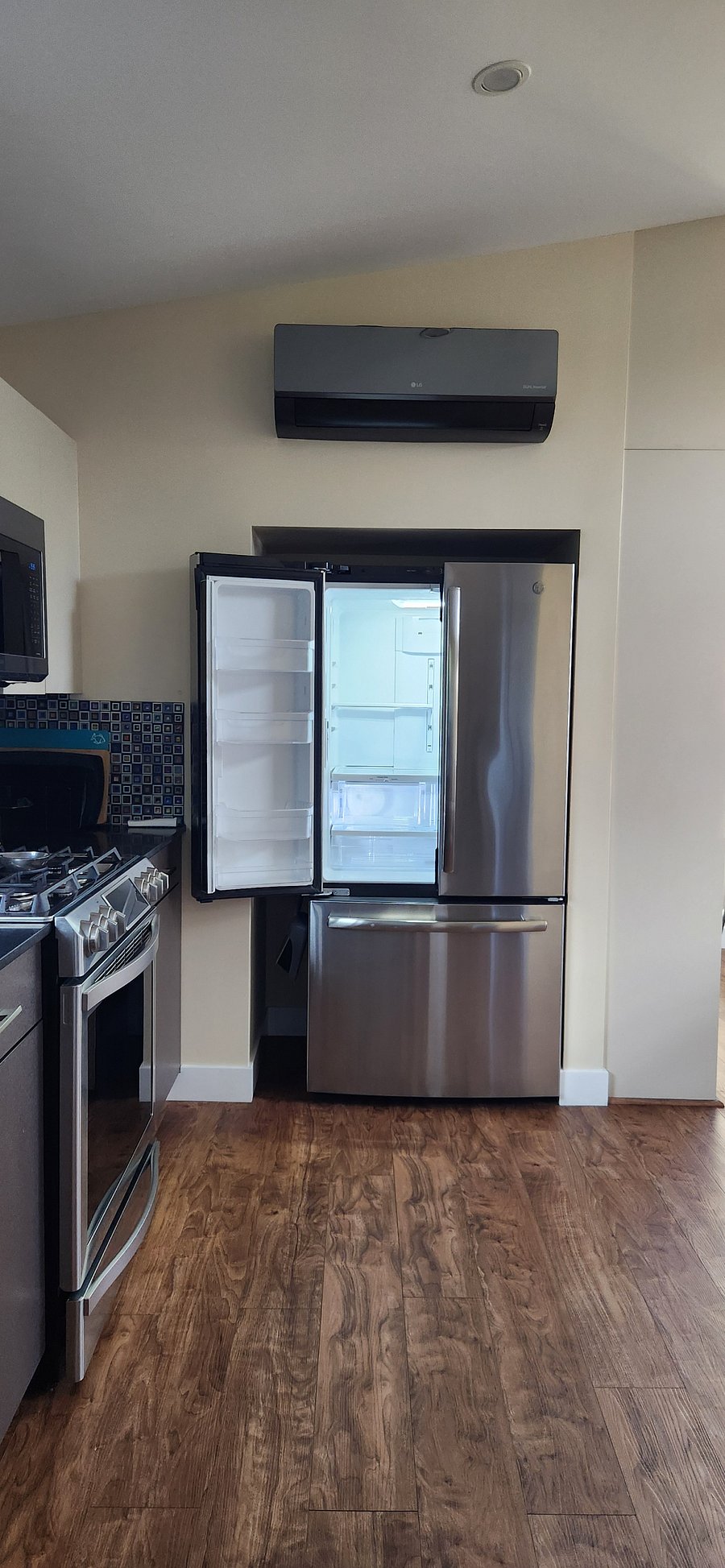 Full-sized refrigerator. The box above it is an a/c and heater wall unit dedicated to the living space.