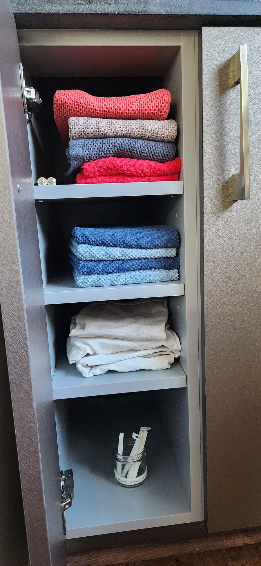 Kitchen towels, aprons, and a space for zip lock, aluminum foil, etc.