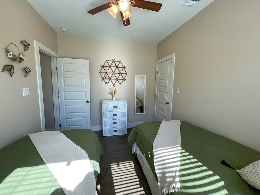 Guest bedroom #1 featuring two extra-long twin beds, chester drawer and walk-in closet.