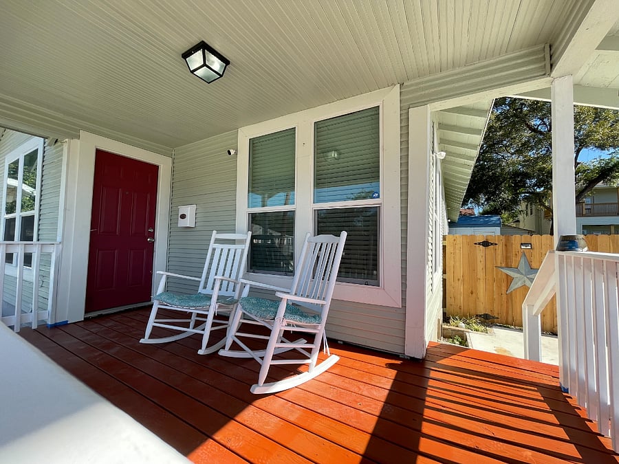 Front porch featuring two rocking chairs. Backyard storage shed has a full home-gym available to guests.