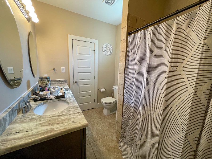 Master bathroom featuring a walk-in closet, double vanity and walk-in shower.
