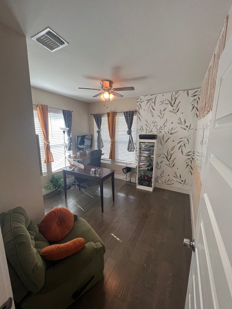 Entrance to guest bedroom #2, the home office featuring two desks (one being an electric standing desk), mounted flatscreen TV to enhance productivity, printer setup (printer not included), two whiteboards, and office chair.