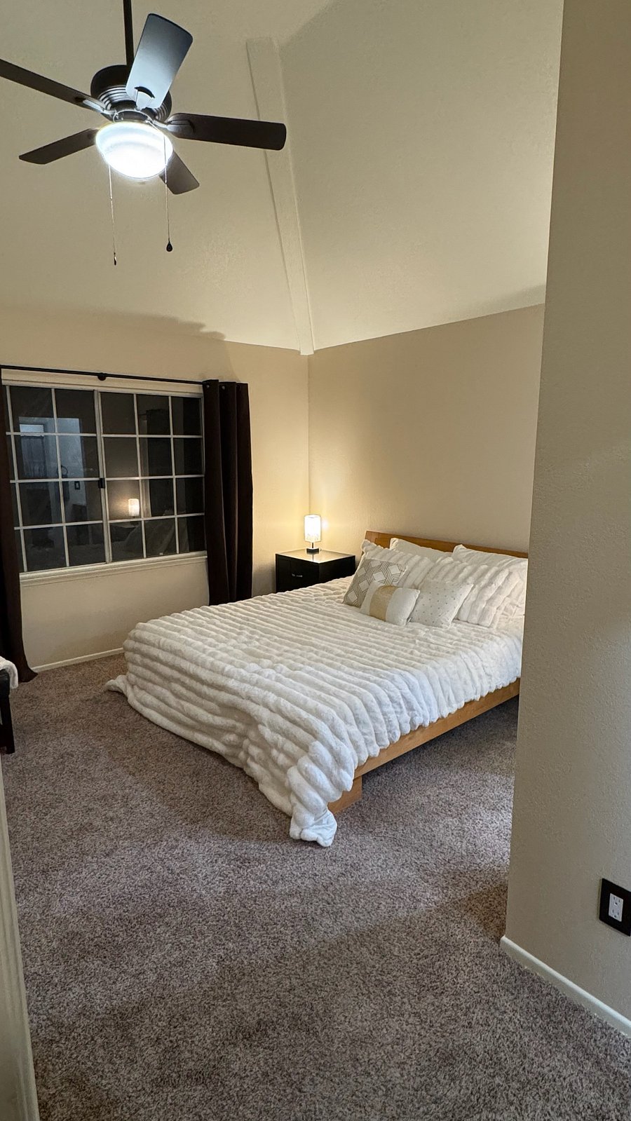 Luxurious king size bed with a nightstand and table lamp on both sides 