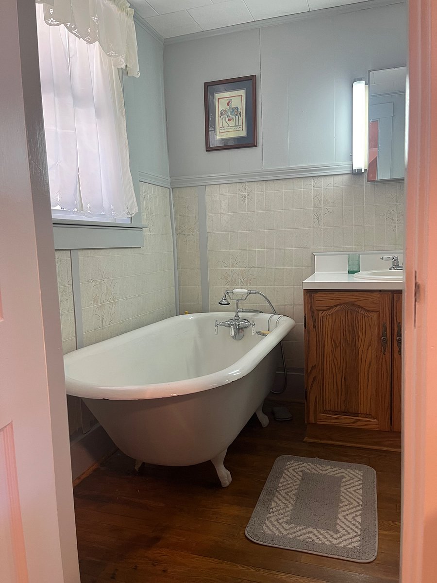 Original farmhouse ball and claw soaking tub with hand held shower.