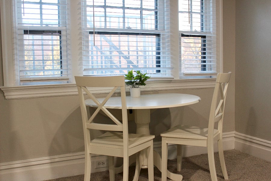 Extendable round dining table and comfortable chairs under the large window