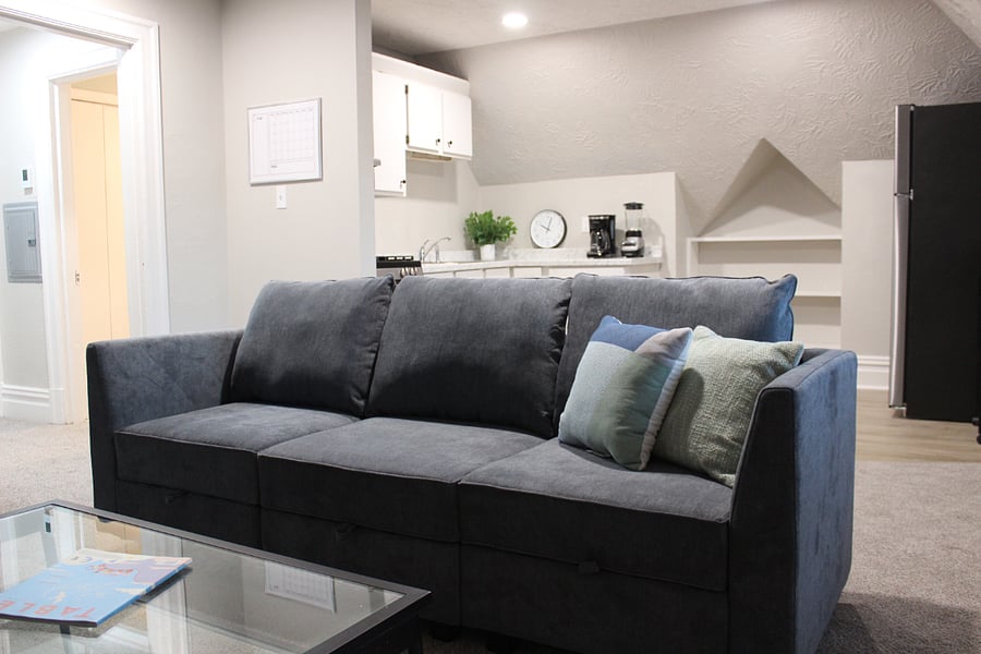 A comfortable full size couch offers storage and a place to relax