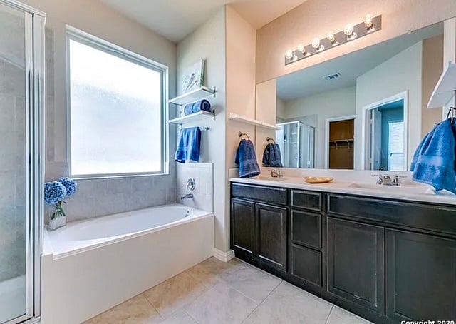 Master en-suite complete with walk-in shower, soaking tub, double sinks, and storage