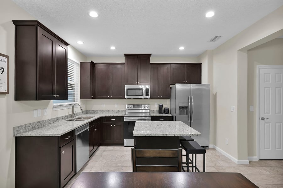 Beautiful kitchen has lots of cabinets, stainless steel appliances, and an island! Granite countertops, too!