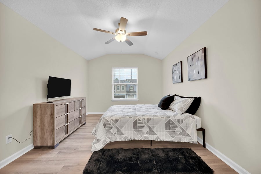 The Primary Suite has a Queen-sized bed, 40-inch smart TV, vaulted ceilings, a large closet, and a private bathroom.