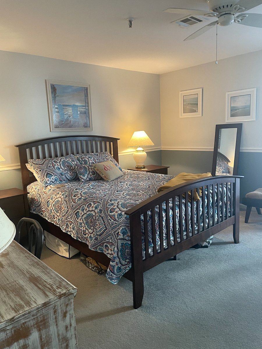 Master bedroom with slider to deck. Ceiling fan and linens.
