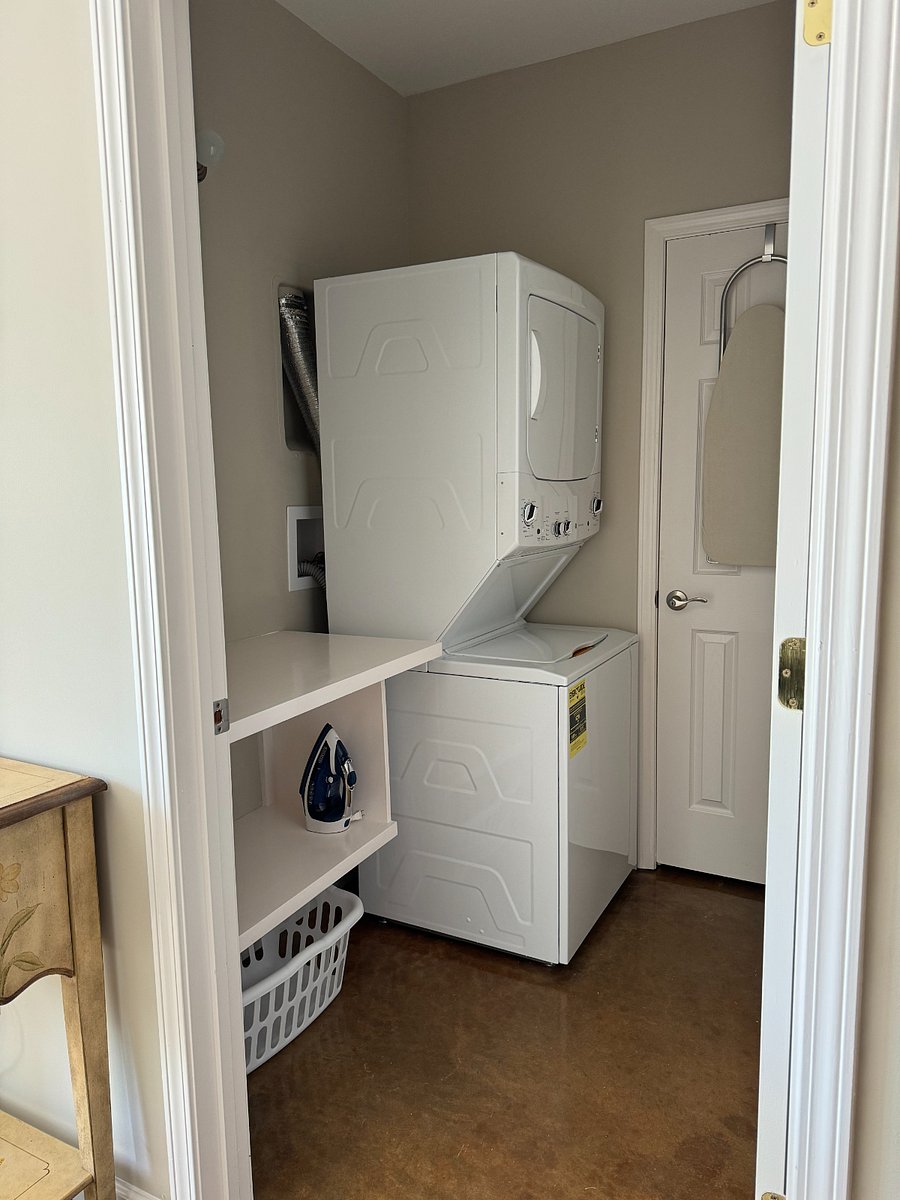Laundry Room with washer and dryer, built-in counter and ironing board in unit.