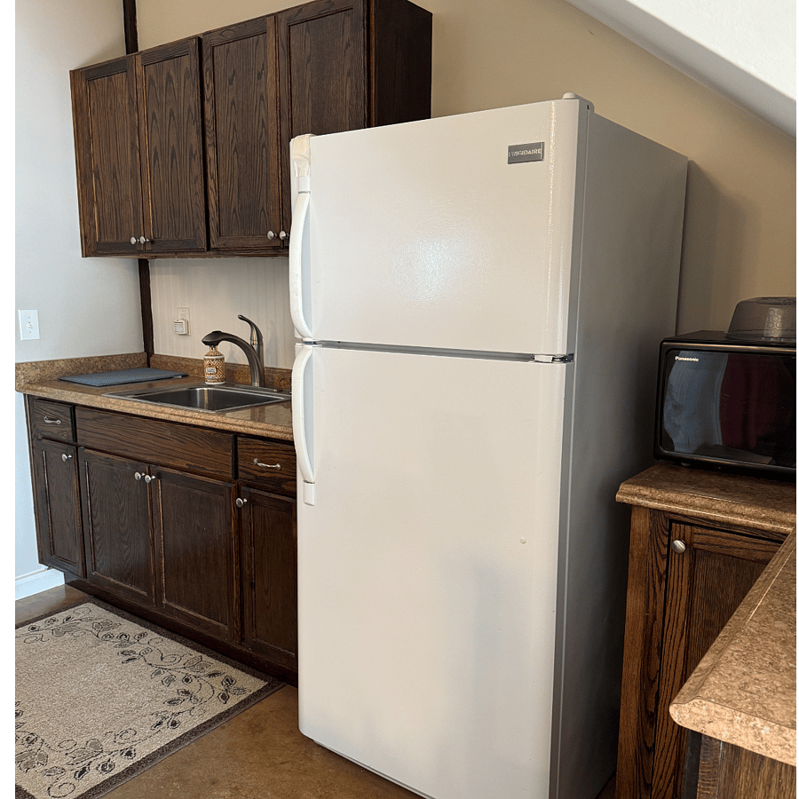 Kitchen w/ full sized refrigerator and microwave