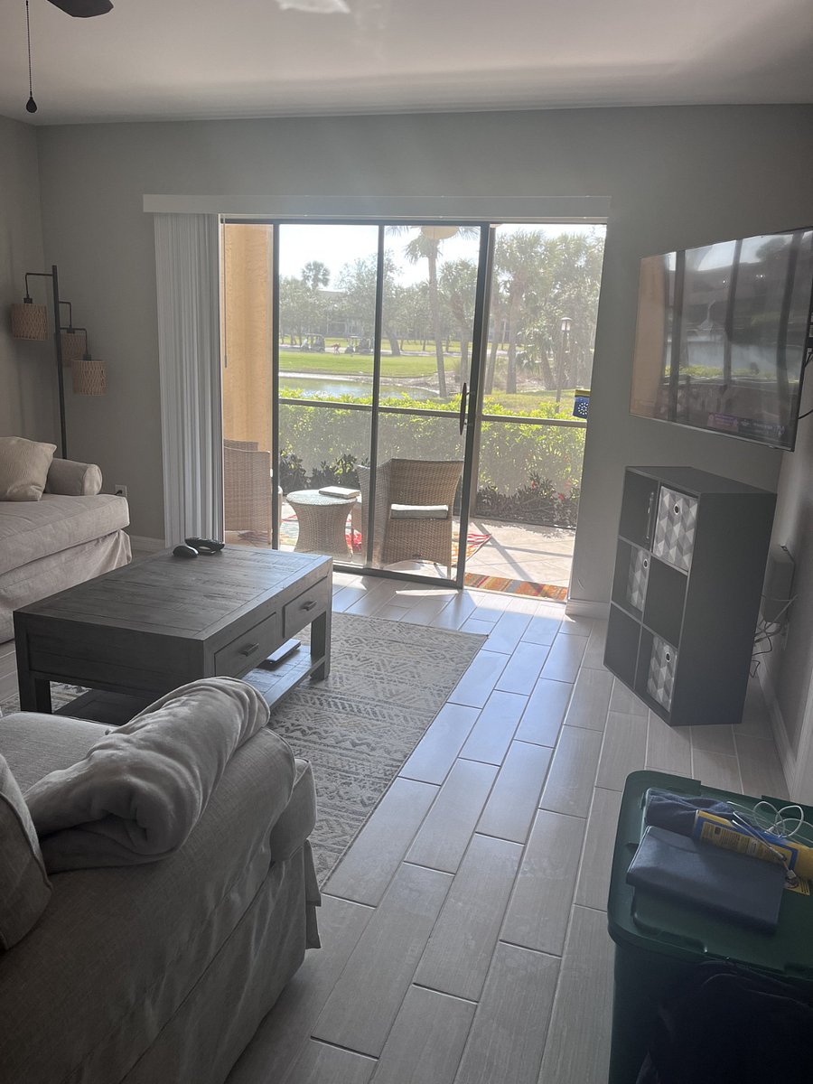 Living room that opens to the back lanai.  Couch and loveseat.  Afternoon sun!