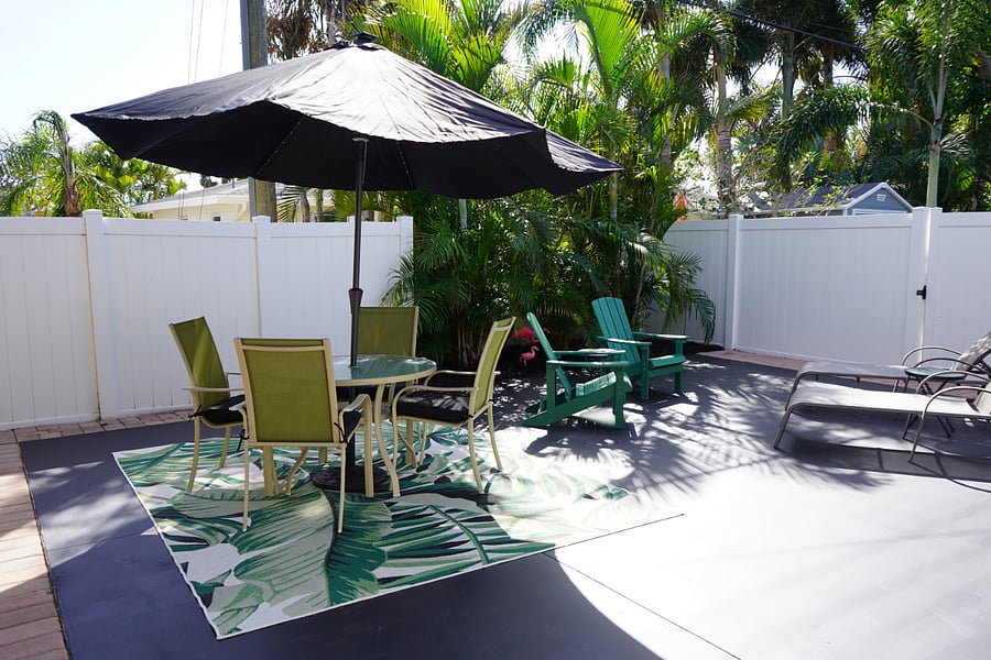 Private patio with several seating options, solar powered led umbrella, electric and storage shed with beach items.
