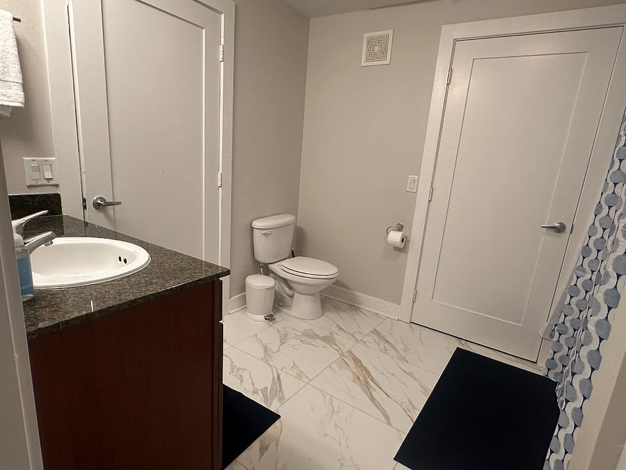 Bathroom has door to the living area and the bedroom. Towels and sheets provided.