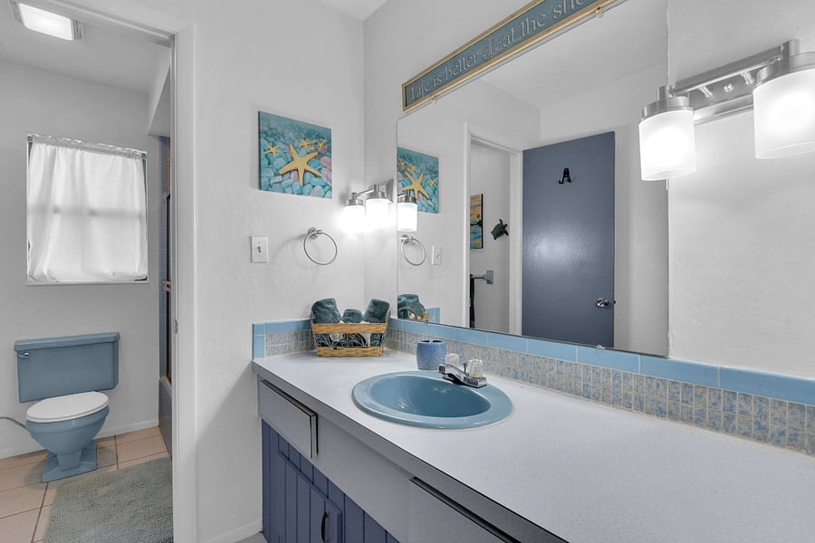 Guest bathroom with large vanity, tub/shower combo and toilet