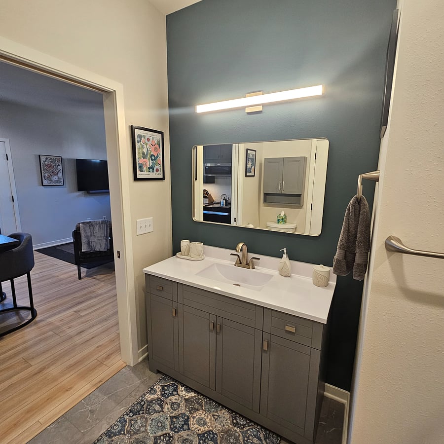 Large bathroom cabinet space with towels, drawers for toiletries, large mirror with nice lighting