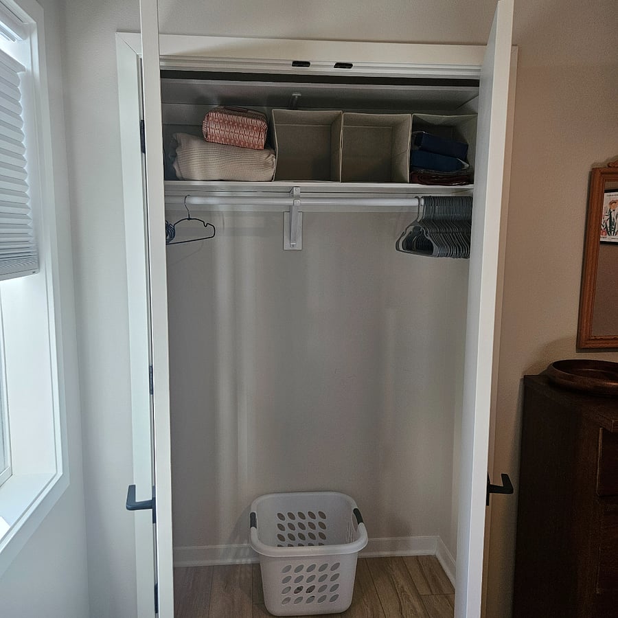 Closet, laundry hamper and extra hangers, iron, ironing board and linens