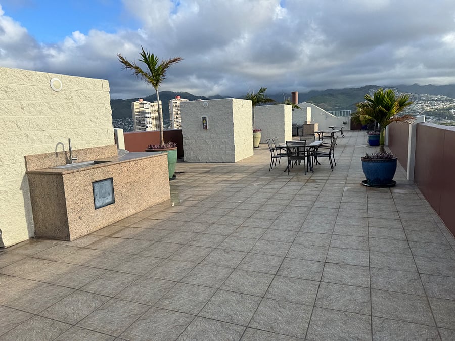 One of a few patio sets with BBQs on rooftop.