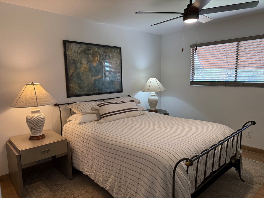 Spacious primary bedroom with room darkening shades.