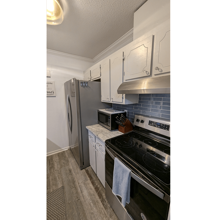 Kitchen with full size, side by side refrigerator, microwave, full size stove/oven