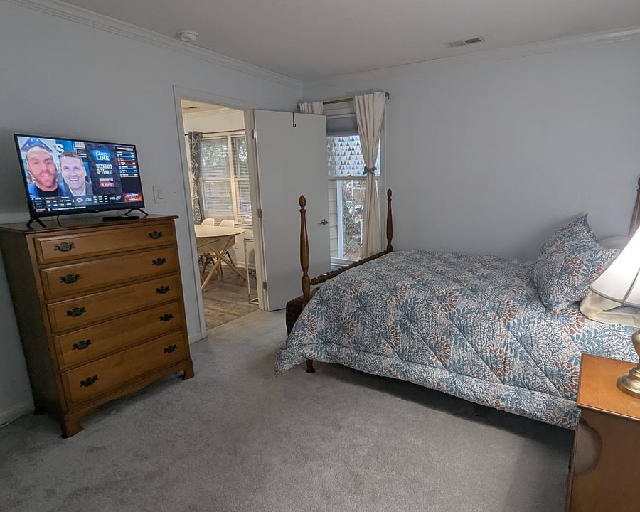 Second bedroom with Smart TV, natural light, and a light blocking shade for sleeping late - looking back toward dining room and den