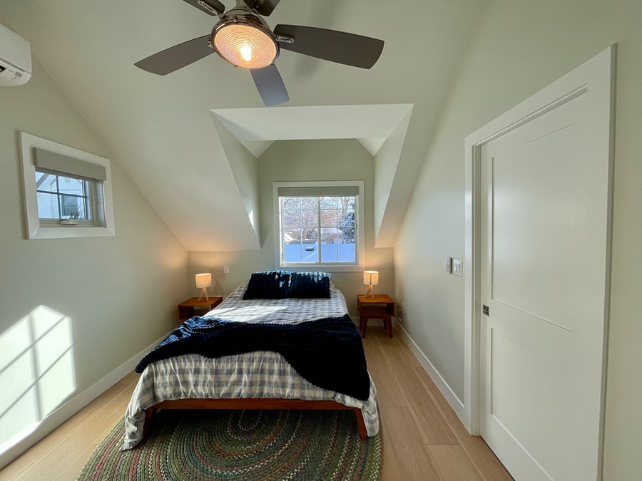 Queen bed in bedroom with desk and pocket door