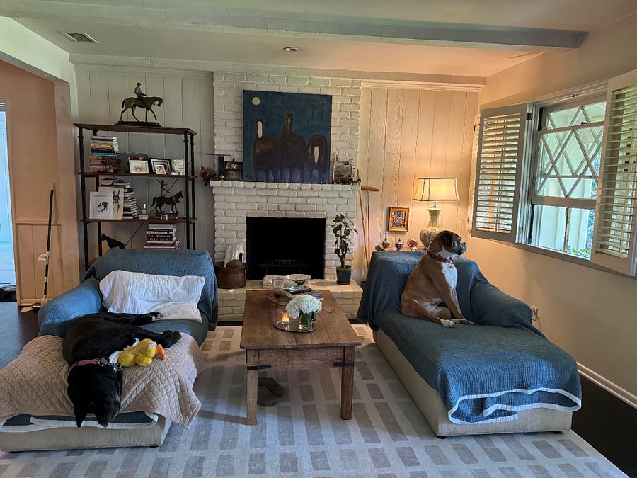 Wood burning fire place at one end of living room and wall mounted television at other end