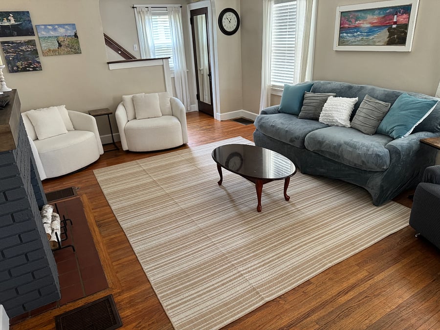 Living Room amenities: Full Couch, Recliner, 2 oversized chairs, coffee table, 2 side tables, small smart TV, coat closet, vacuum.