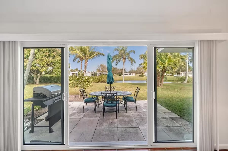 Sunroom views to outdoor entertainment area and lake