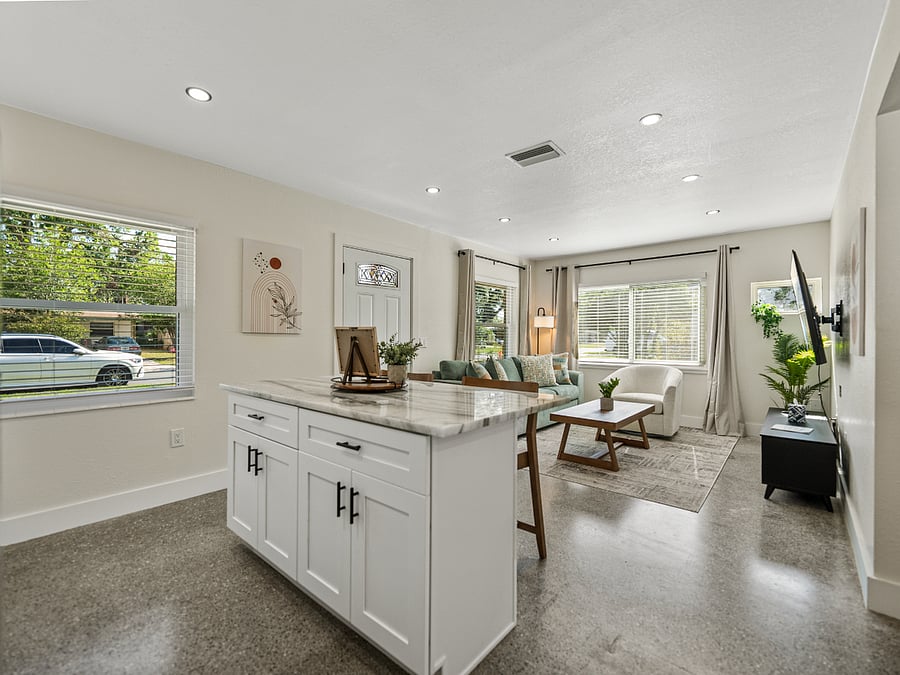 This open-concept kitchen blends style and functionality with a central island for meal prep and casual dining. Featuring modern stainless steel appliances, granite countertops, and minimalist cabinetry, its bright, airy, and perfect for everyday.