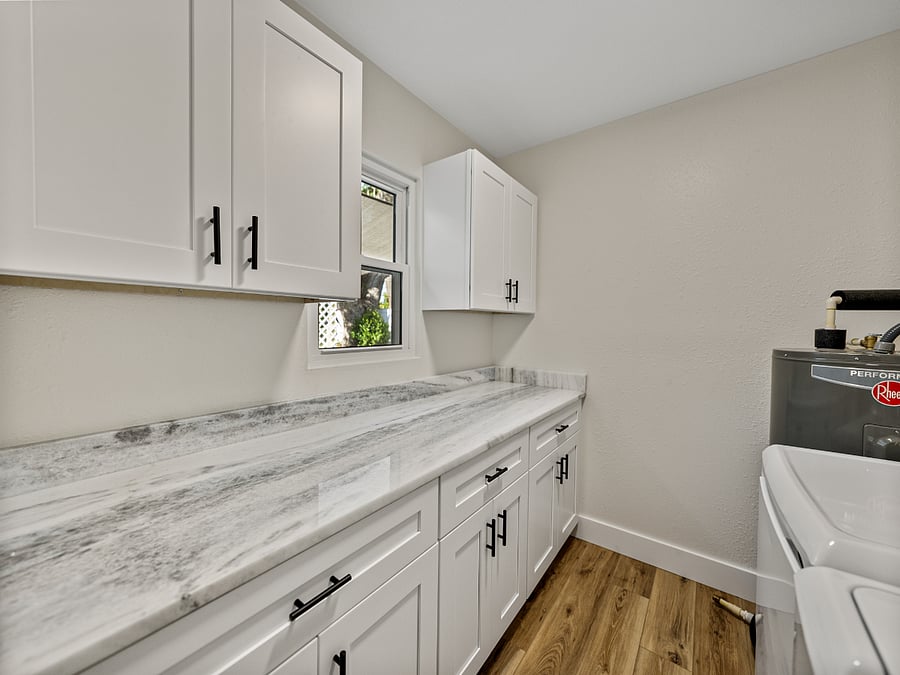 This sleek laundry area features a full-size washer and dryer, granite folding space, and ample storage. Hidden inside: a surprise stash of board gamesperfect for chores or family fun!