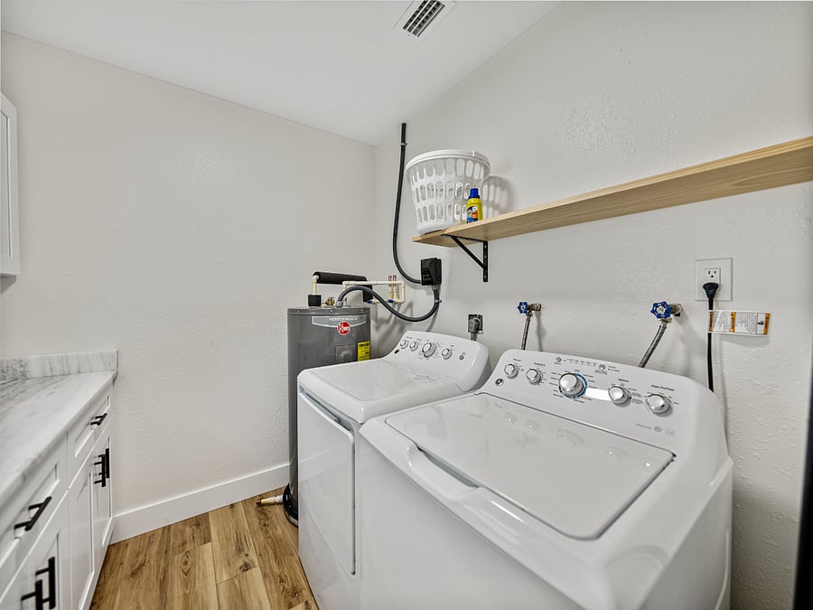 This sleek laundry area features a full-size washer and dryer, granite folding space, and ample storage. Hidden inside: a surprise stash of board gamesperfect for chores or family fun!