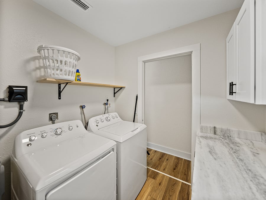 This sleek laundry area features a full-size washer and dryer, granite folding space, and ample storage. Hidden inside: a surprise stash of board gamesperfect for chores or family fun!