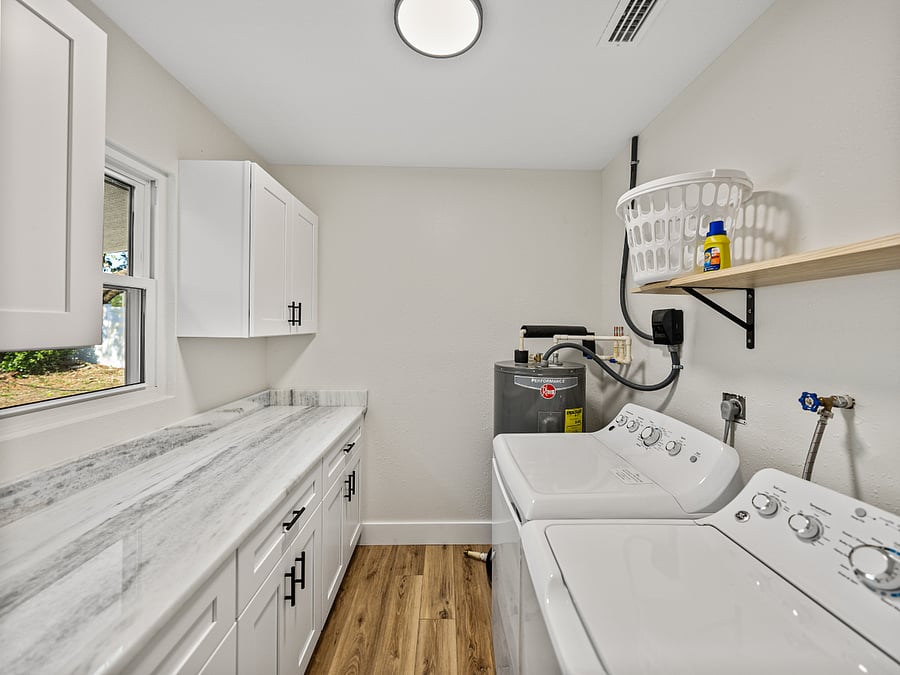 This sleek laundry area features a full-size washer and dryer, granite folding space, and ample storage. Hidden inside: a surprise stash of board gamesperfect for chores or family fun!