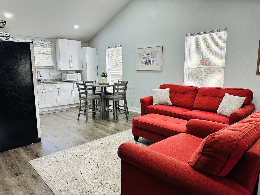 Welcome to this bright, open-concept living room and kitchen! Vaulted ceilings enhance the airy vibe, with natural light pouring in. Perfect for relaxing or sharing meals, this cozy space is designed for comfort and connection.