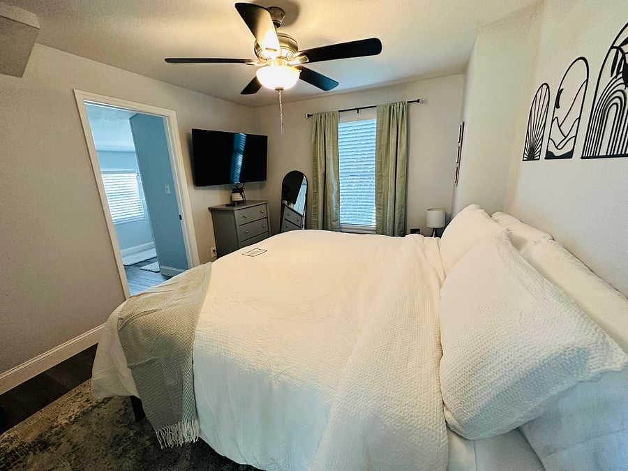 Unwind in this cozy master bedroom featuring a plush king-size bed with soft bamboo sheets, a cotton comforter, and warm, inviting dcor with room darkening shades. Roku TV with access to favorite apps along with complimentary Netflix and Roku TV.