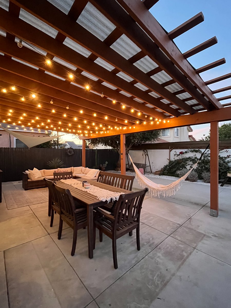 large outdoor covered patio space including seating, dining space, and hammock